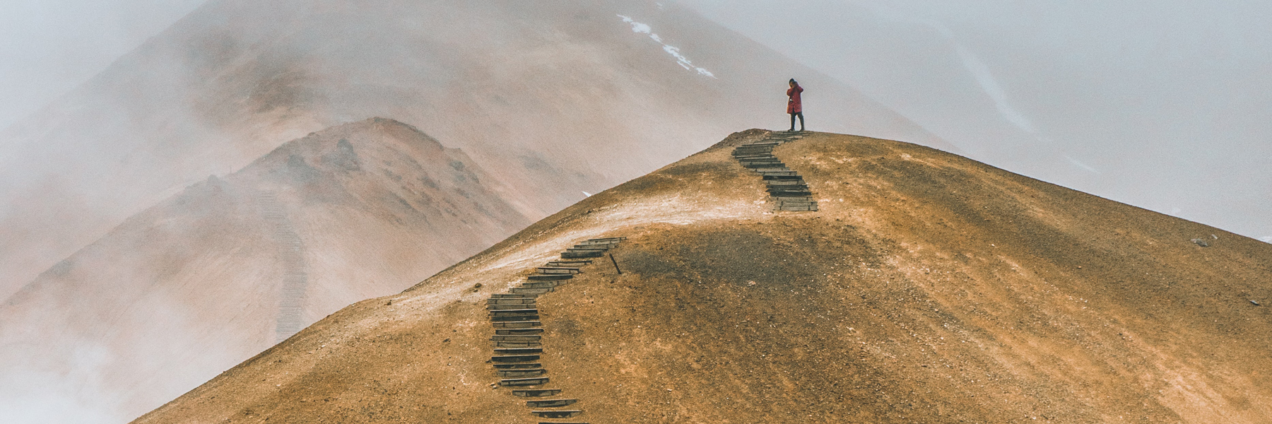 Image of person onto of hill with stair pathway leading to his current position
